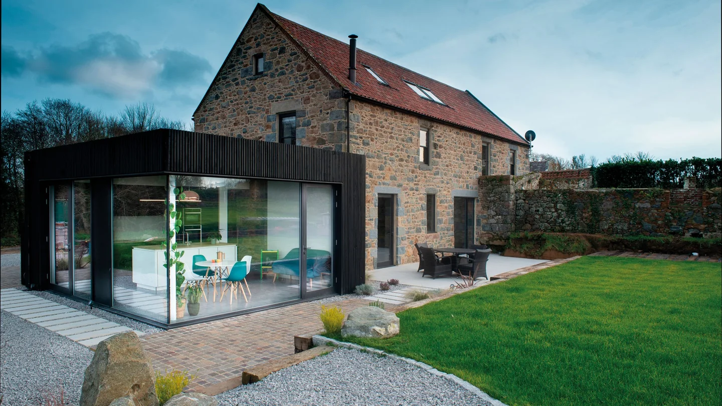 Contemporary glazed extension to a traditional stone house
