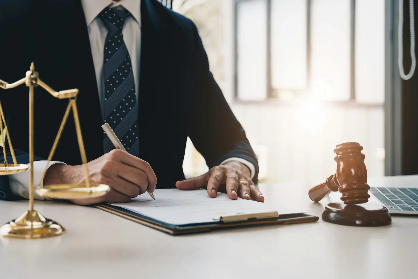 Property professional reviewing documents beside scales of justice