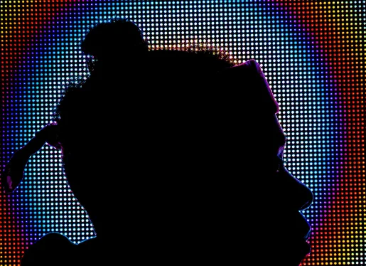 Silhouette of a person against a digital display